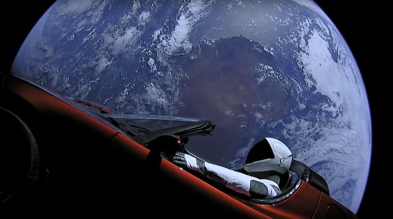 Vista del coche Telsa en el espacio con la Tierra de fondo.